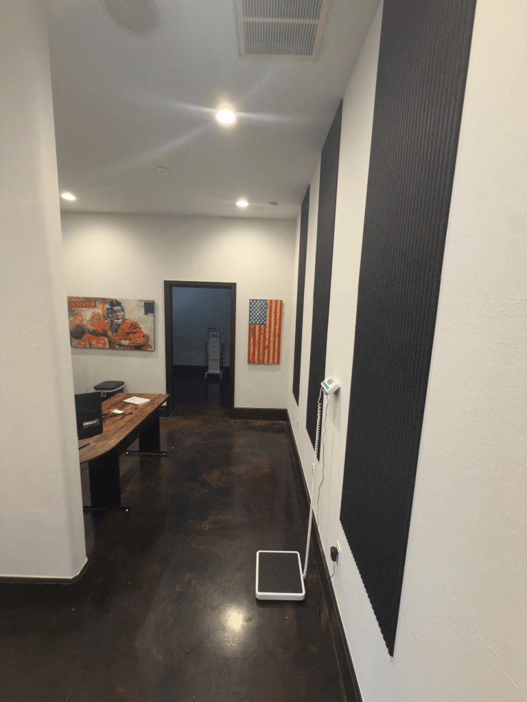 Clinic hallway at Oak & Sage Wellness Center in Edmond with a digital scale and view into a treatment room